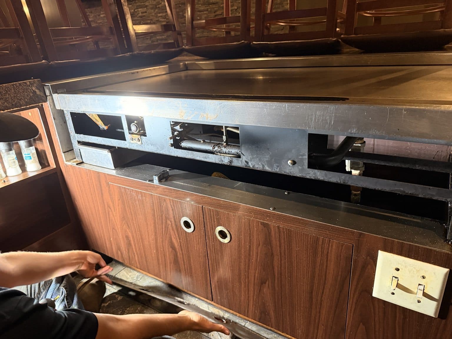 Open service panel on a commercial griddle, showing the gas valve and igniter area