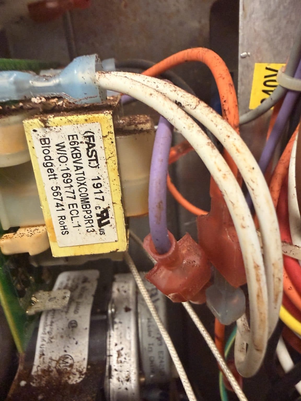 Close-up of a commercial oven electrical component during diagnostic work